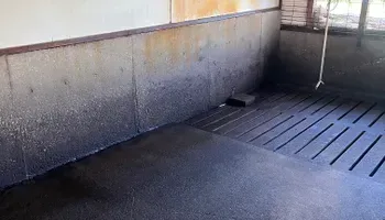 A room with a concrete wall and a black floor.