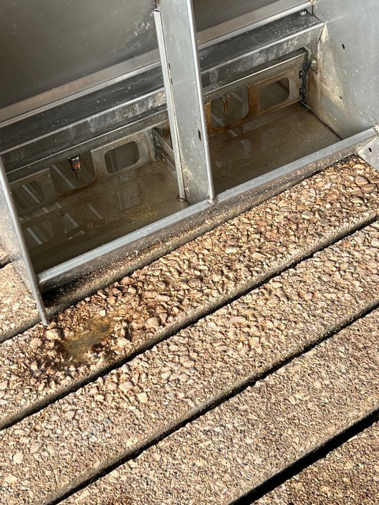 A close up of a wooden floor with a metal container in the background.