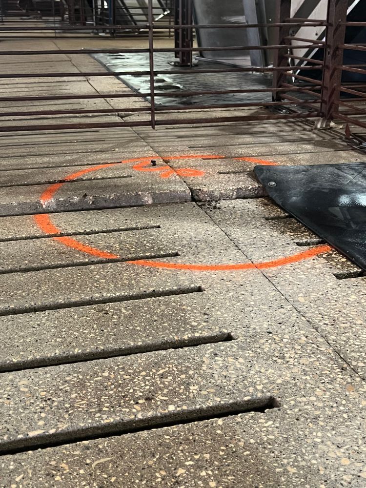 A concrete floor with a circle painted in orange on it.