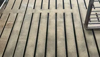 A close up of a wooden deck with black stripes on it.