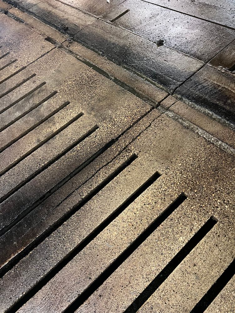 A close up of a drain on a concrete floor.