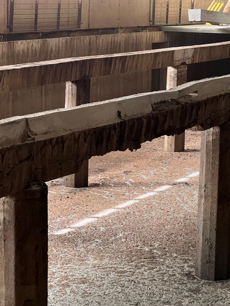 A close up of a concrete structure with a broken beam.