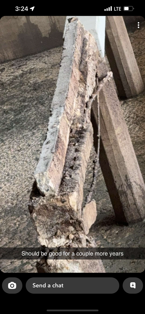 A person is taking a picture of a piece of wood on their phone.