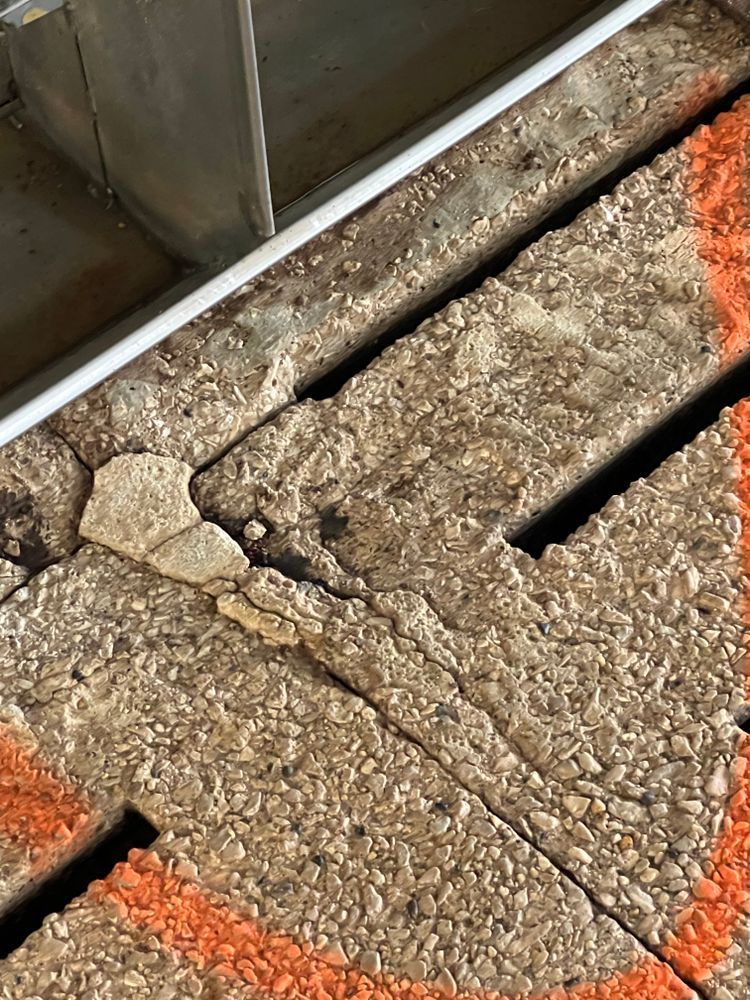 A close up of a concrete floor with a broken piece of concrete.