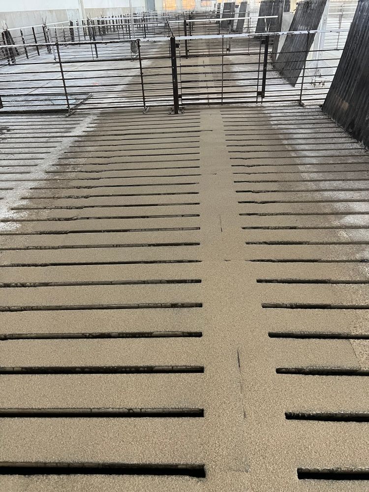 A close up of a concrete walkway with a fence in the background.