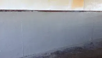 A close up of a gray wall with a black border.