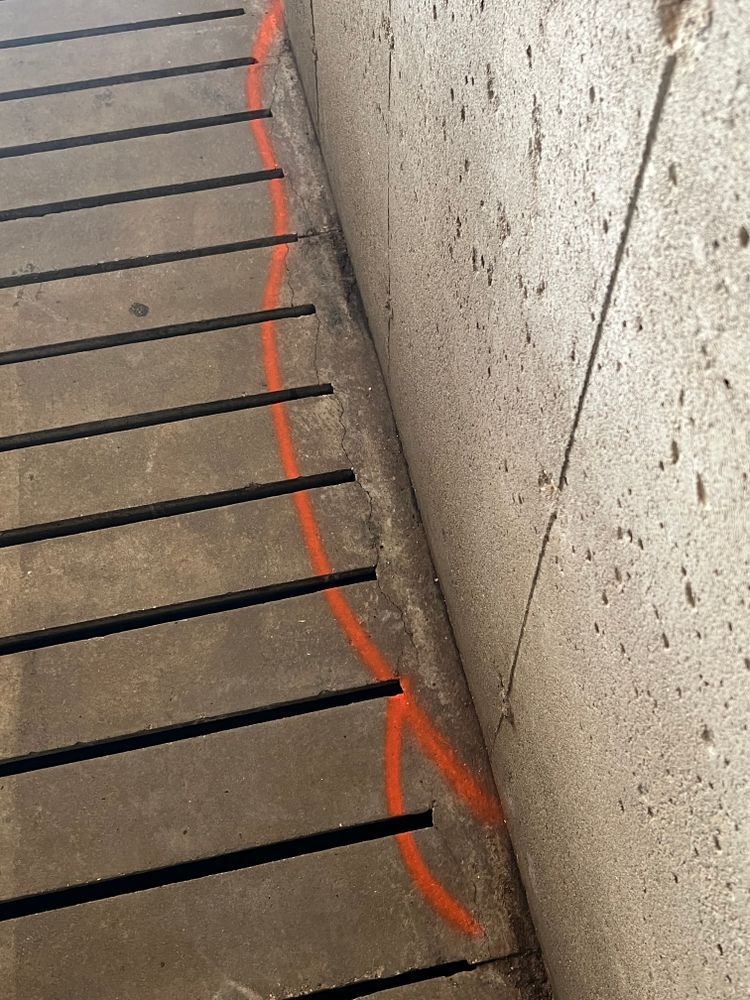 A close up of a concrete wall with a red line drawn on it.