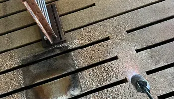 A person is using a torch on a wooden floor.