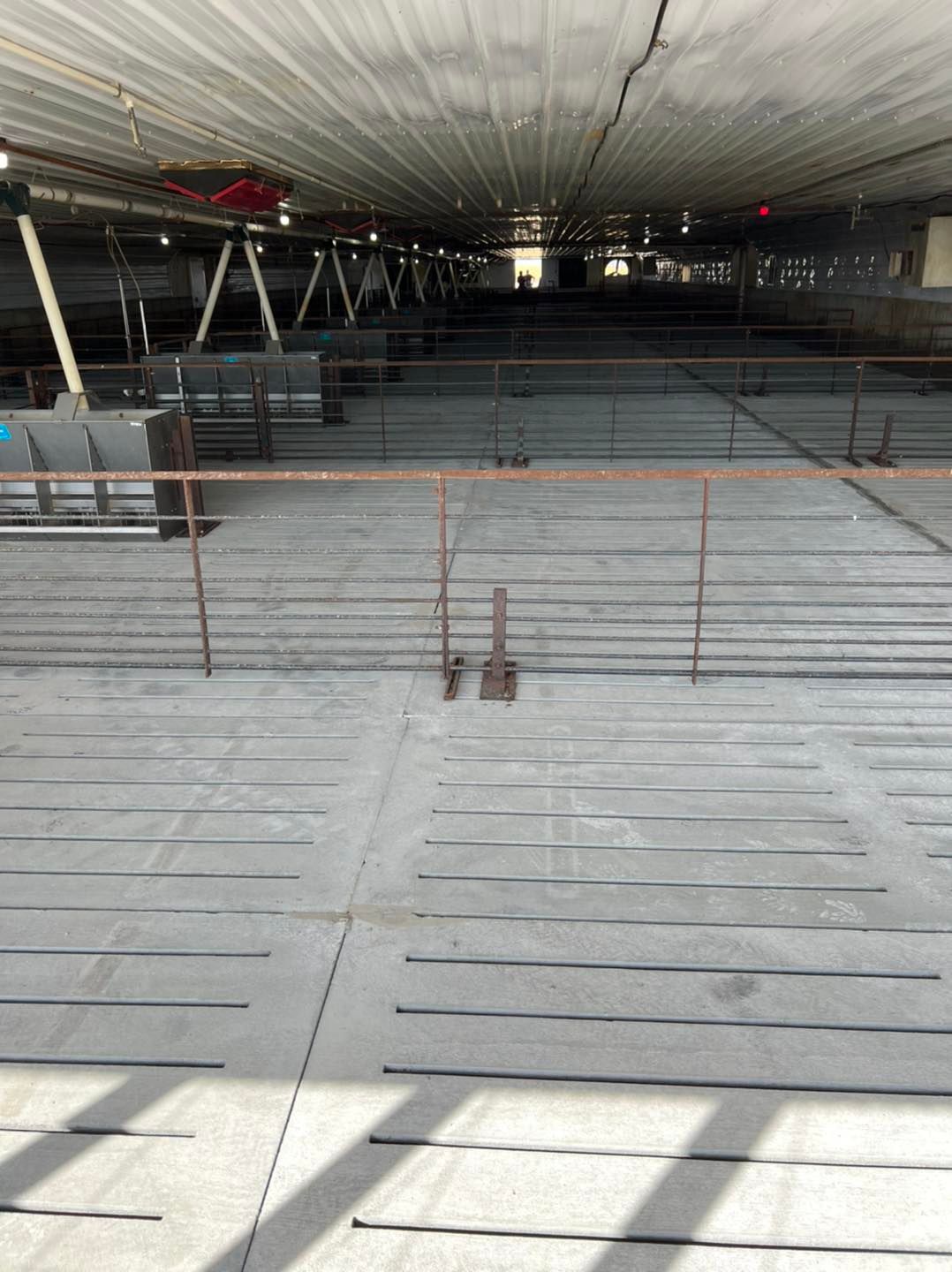 A concrete floor in a building with a metal railing