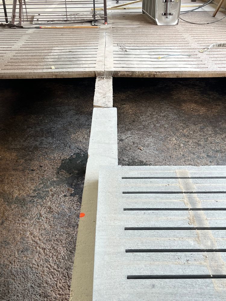 A concrete floor with a wooden floor in the background.