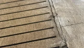 A close up of a brick walkway next to a concrete walkway.