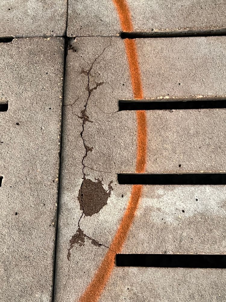 A close up of a cracked concrete surface with a red line.