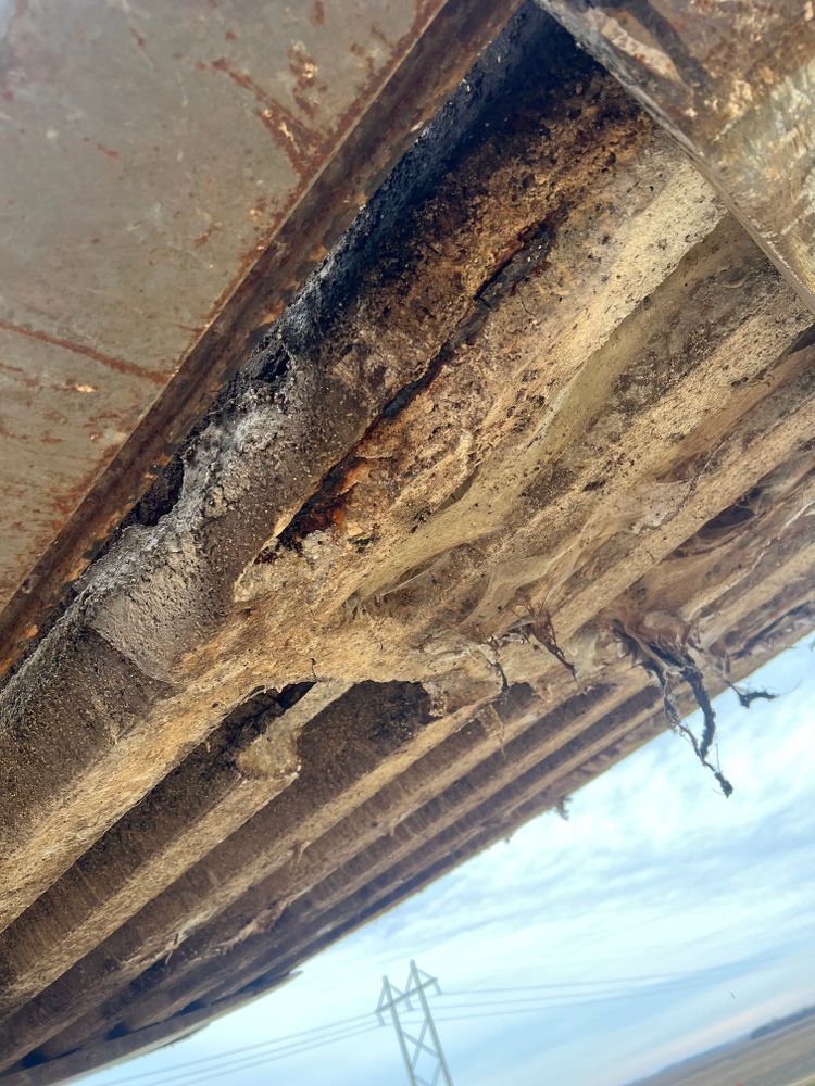 A close up of a rusty metal structure with power lines in the background.
