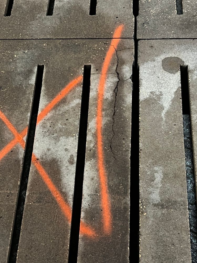 A close up of a concrete grate with a triangle drawn on it