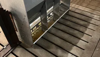 A metal shelf is sitting on top of a wooden floor.