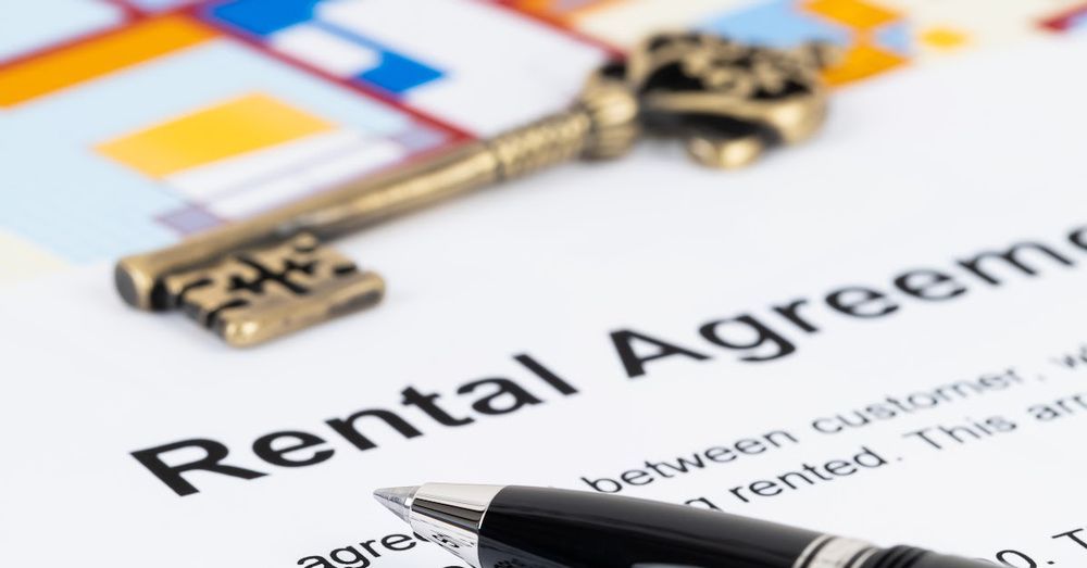 A rental agreement with a key and a pen on it
