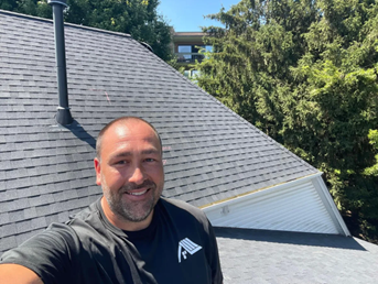 A man is taking a selfie on the roof of a house. A man is taking a selfie on the roof of a house.
