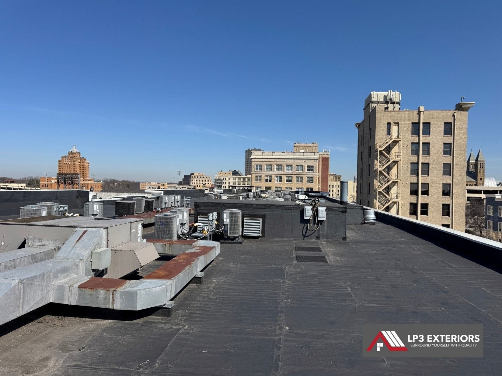 The roof of a building with a lot of buildings in the background