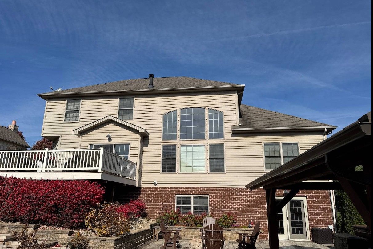 A large house with a large deck and a gazebo in front of it.