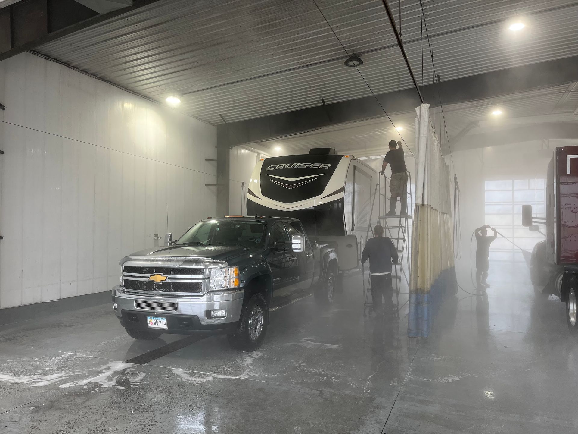 A truck is being washed in a car wash.