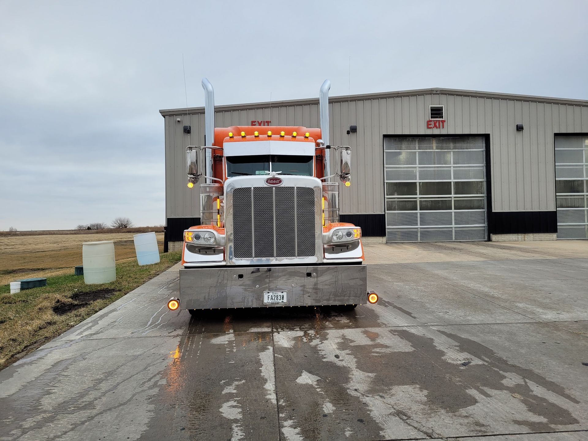 A semi truck is parked in front of a building.