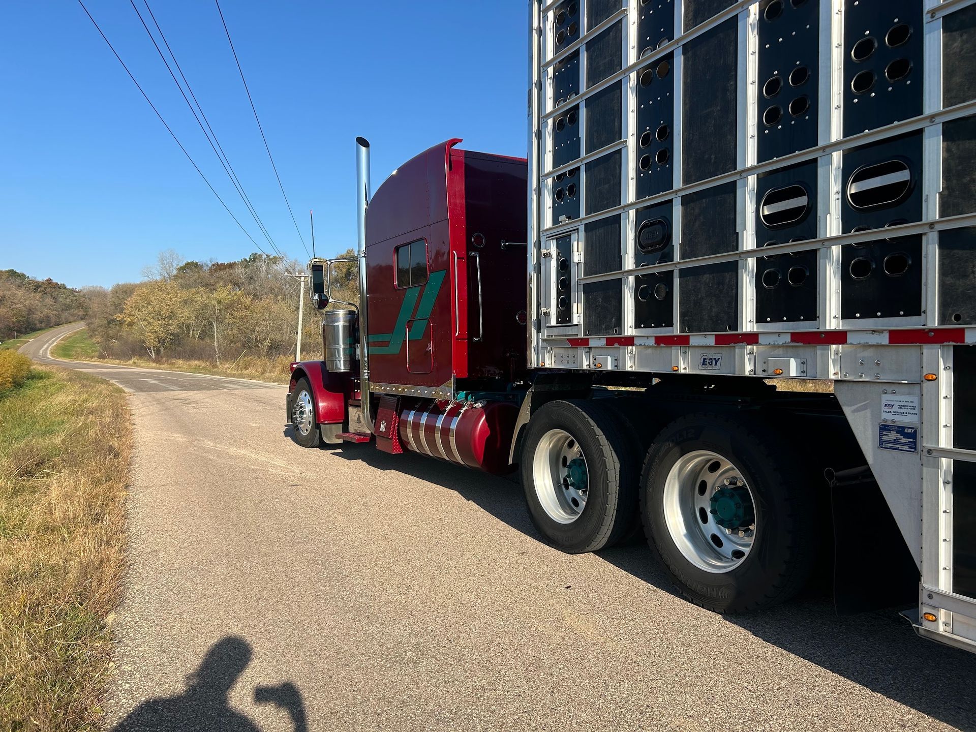 A red semi truck is parked on the side of a road