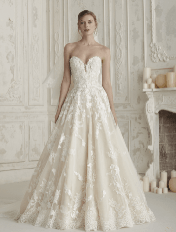 Ivory strapless lace wedding gown with a fitted bodice and full train, displayed in an elegant room