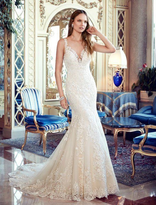 Woman in a sparkling white gown standing in an ornate blue-and-gold room