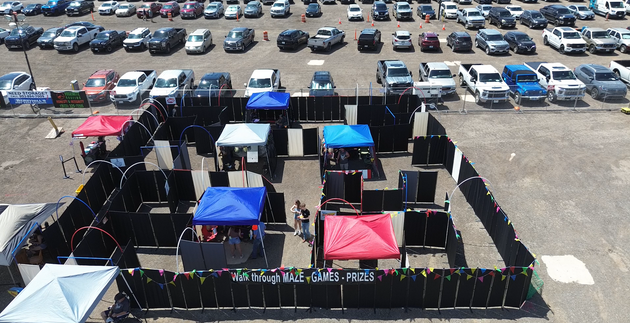 A row of black curtains are covering a gravel path.