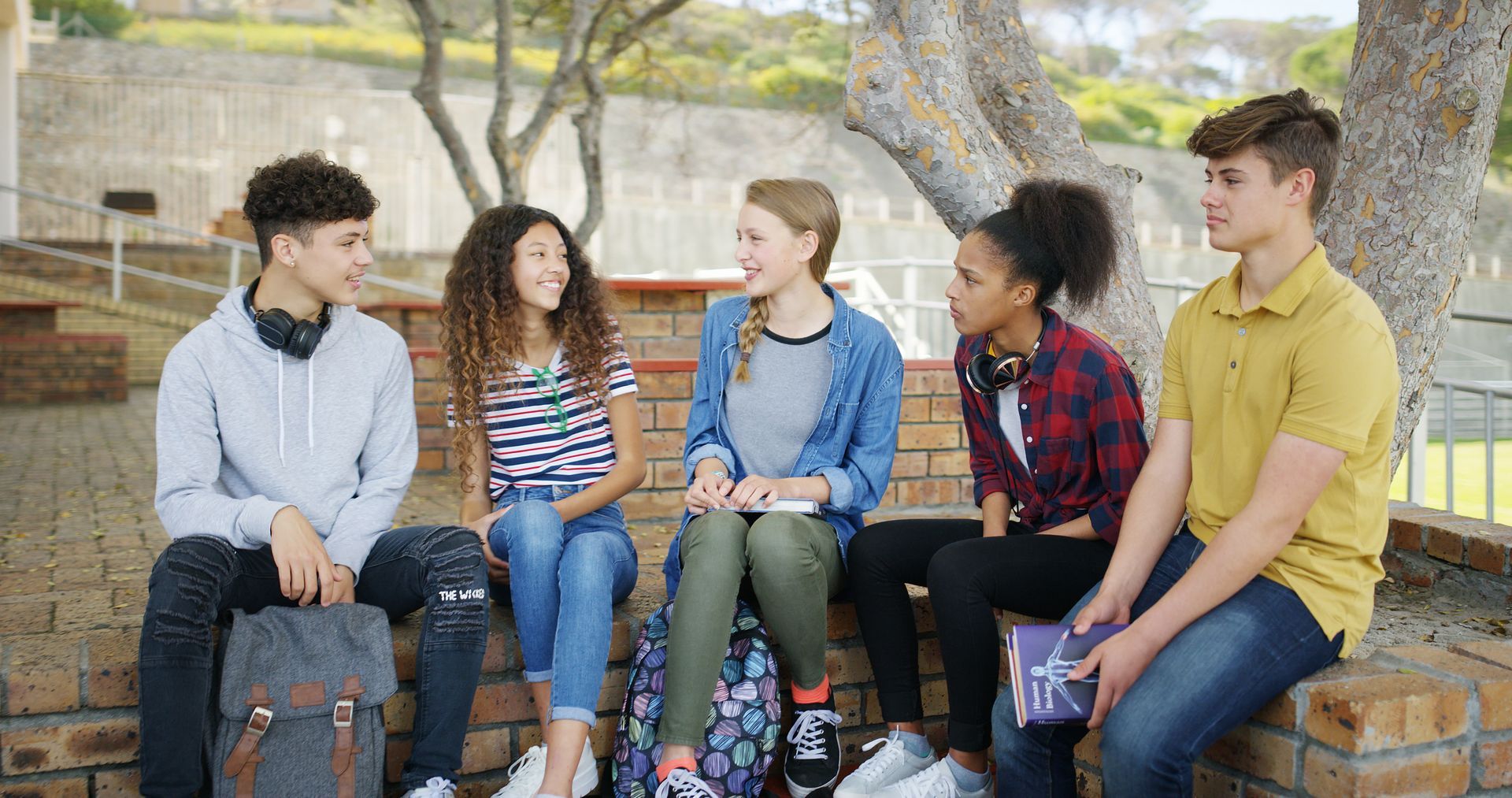 Students in a classroom working on papers. Teacher standing.
