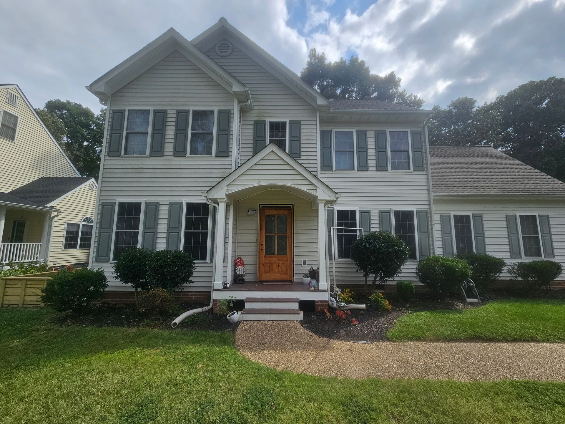 A large white house with a porch and shutters