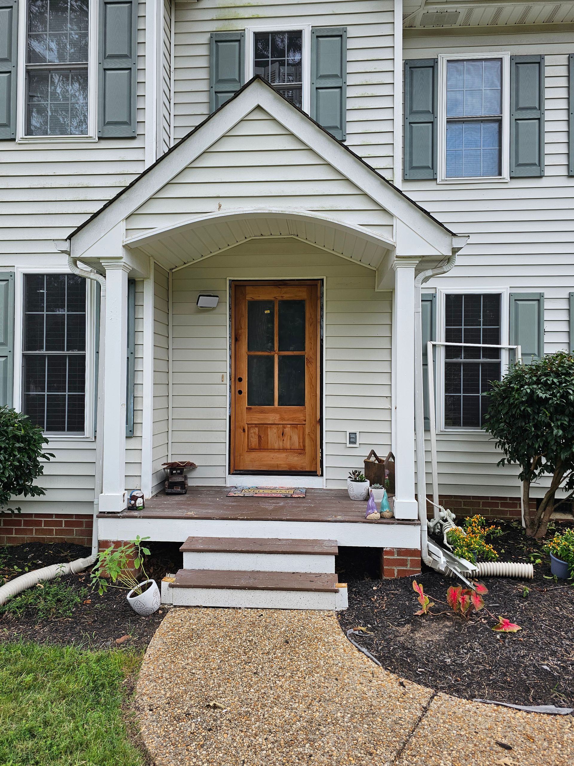 A white house with a porch and a wooden door