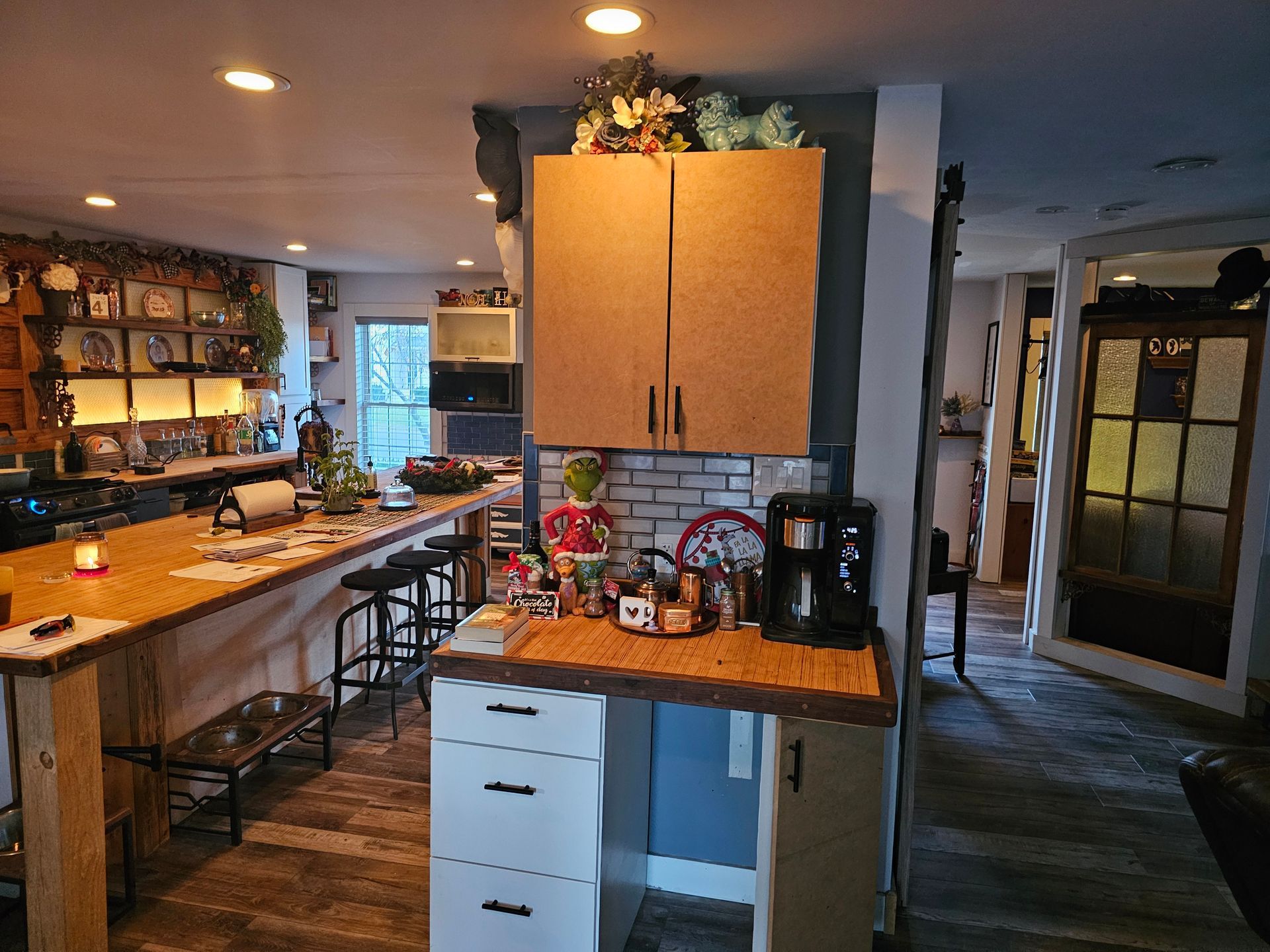 A kitchen with wooden cabinets , a counter , a coffee maker , and a large island.