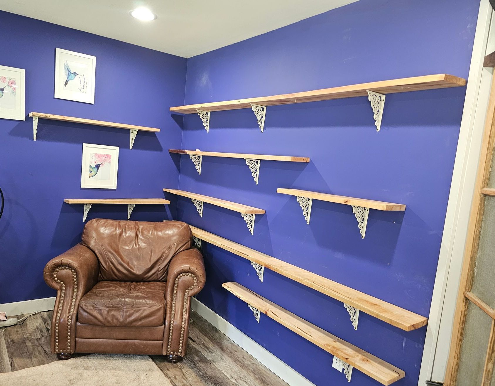 A room with a chair and shelves on the wall