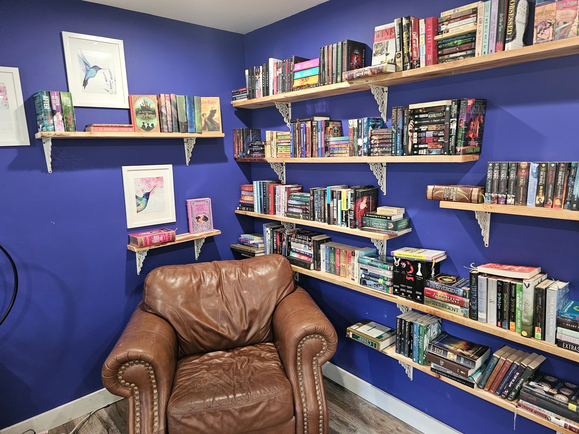 A chair is sitting in front of a bookshelf filled with books.