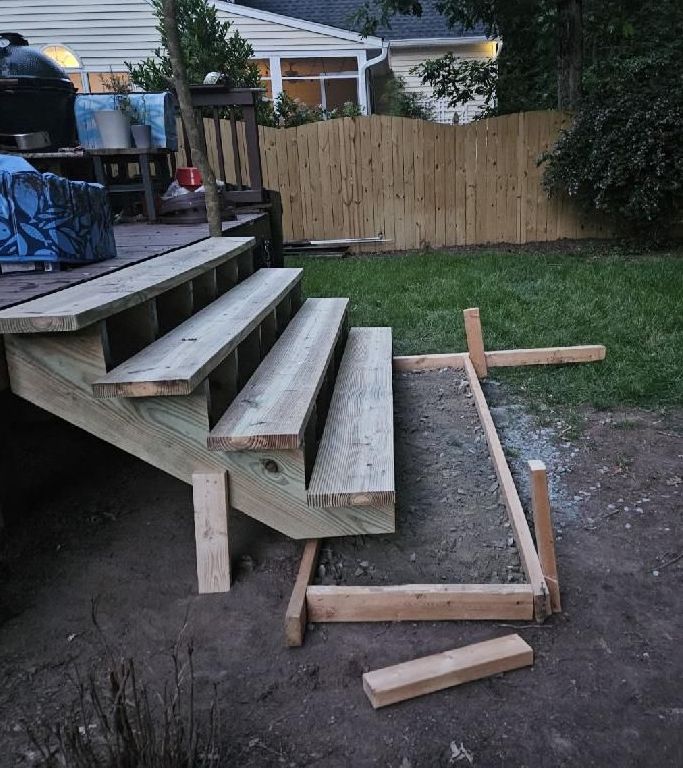 A wooden staircase is being built in a backyard