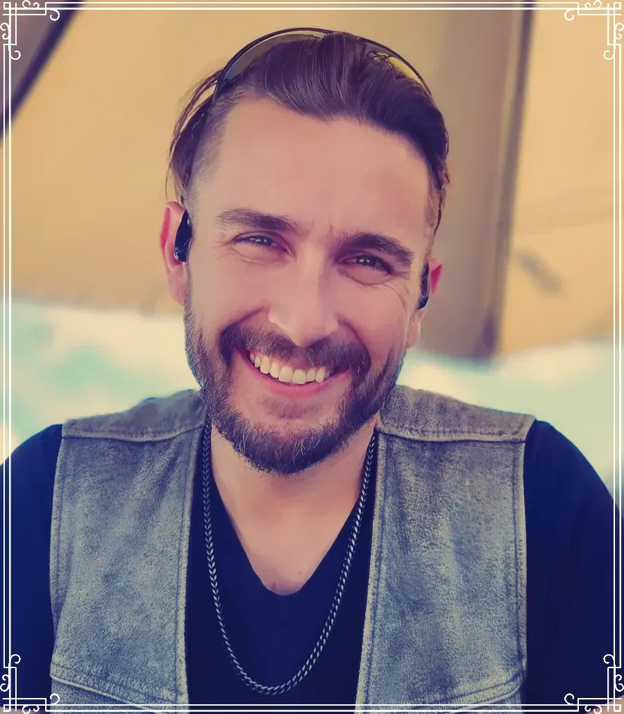 A man with a beard is smiling for the camera