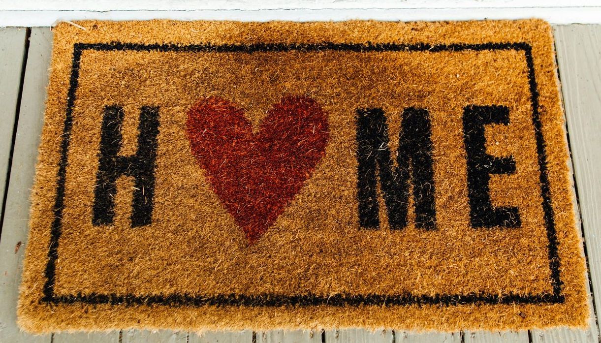 A door mat that says home with a heart on it