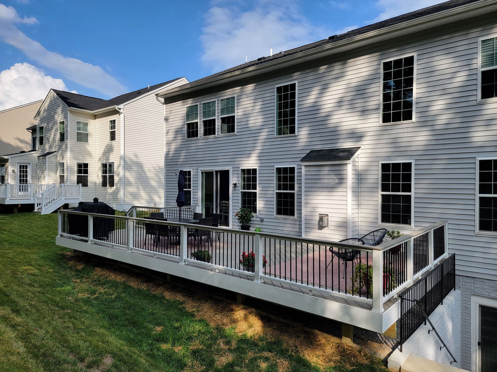 A large white house with a large deck in front of it.