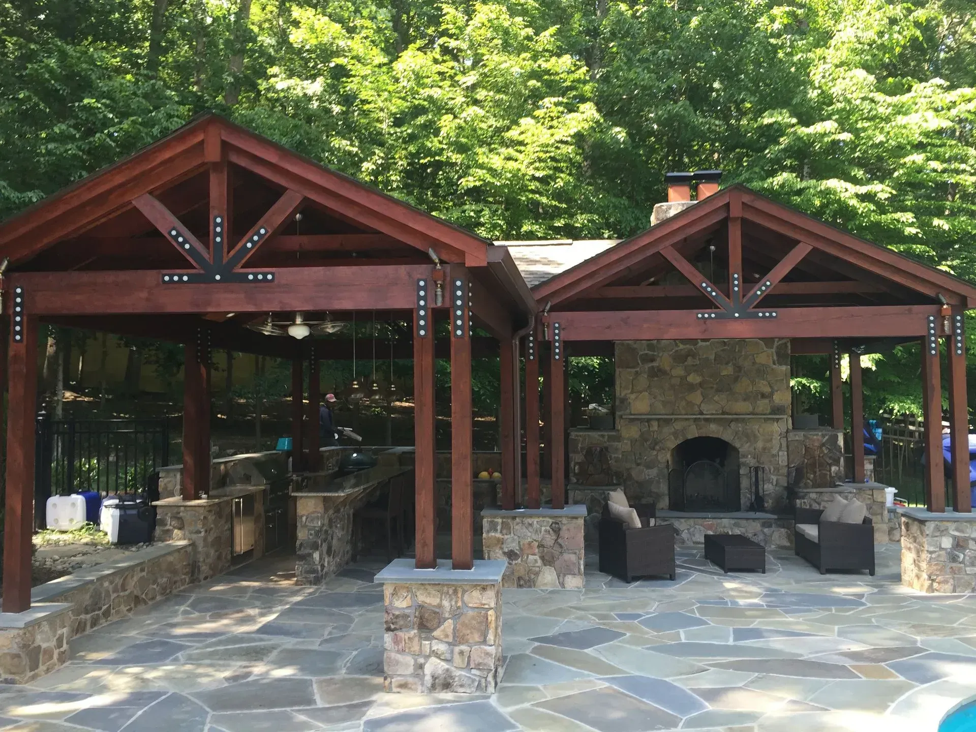 A wooden pavilion with a fireplace in the middle of it