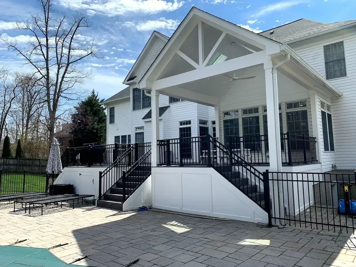 A large white house with a large porch and stairs leading to it.