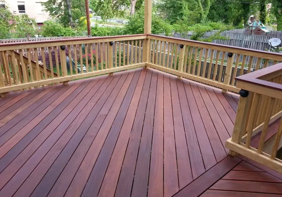 A large wooden deck with a wooden railing