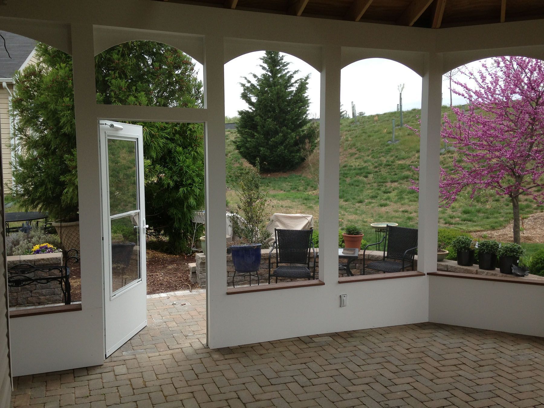 A patio with arched windows and a brick floor