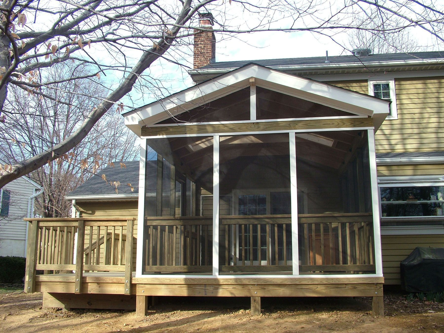A screened in porch in front of a house