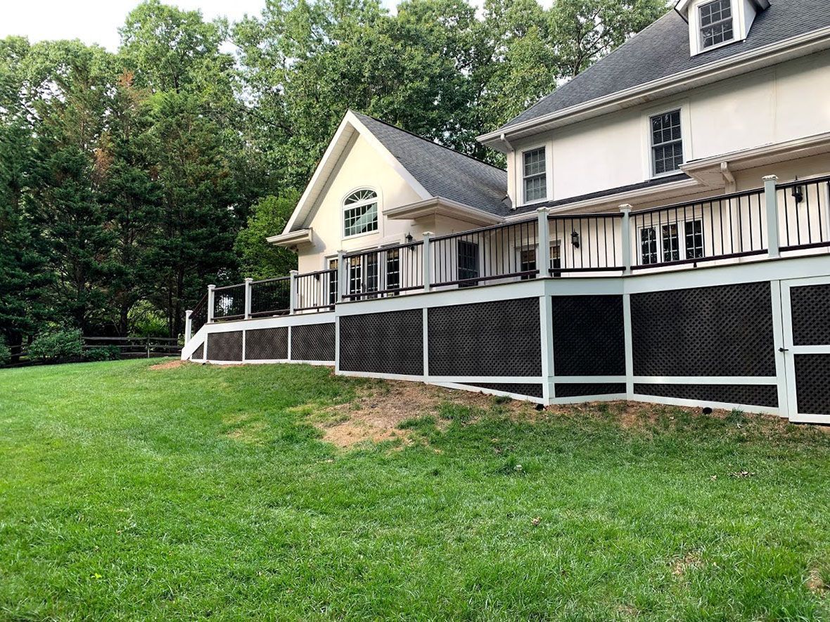A large house with a fence around it and a large lawn in front of it.