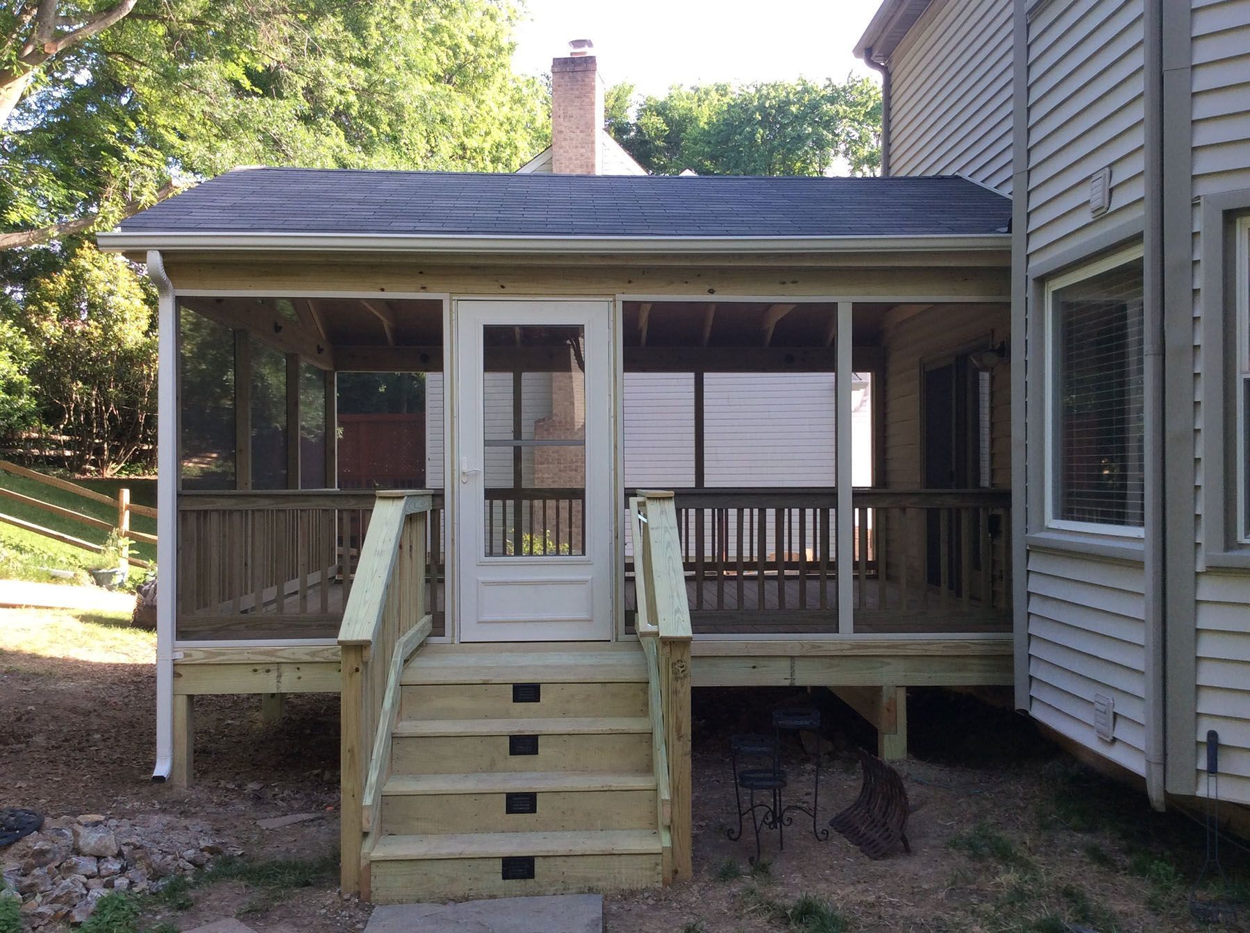 A screened in porch on the side of a house