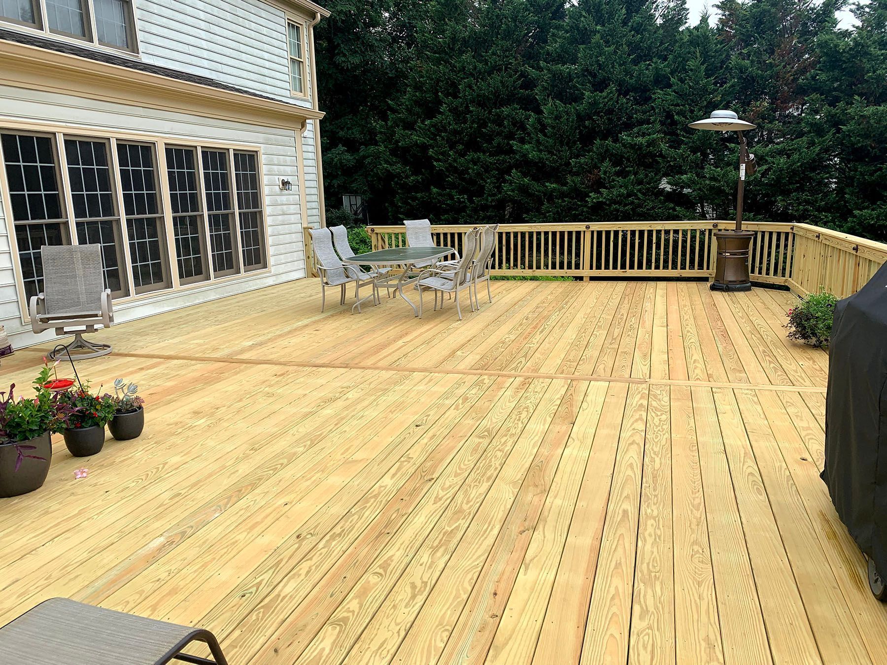 A large wooden deck with a table and chairs on it