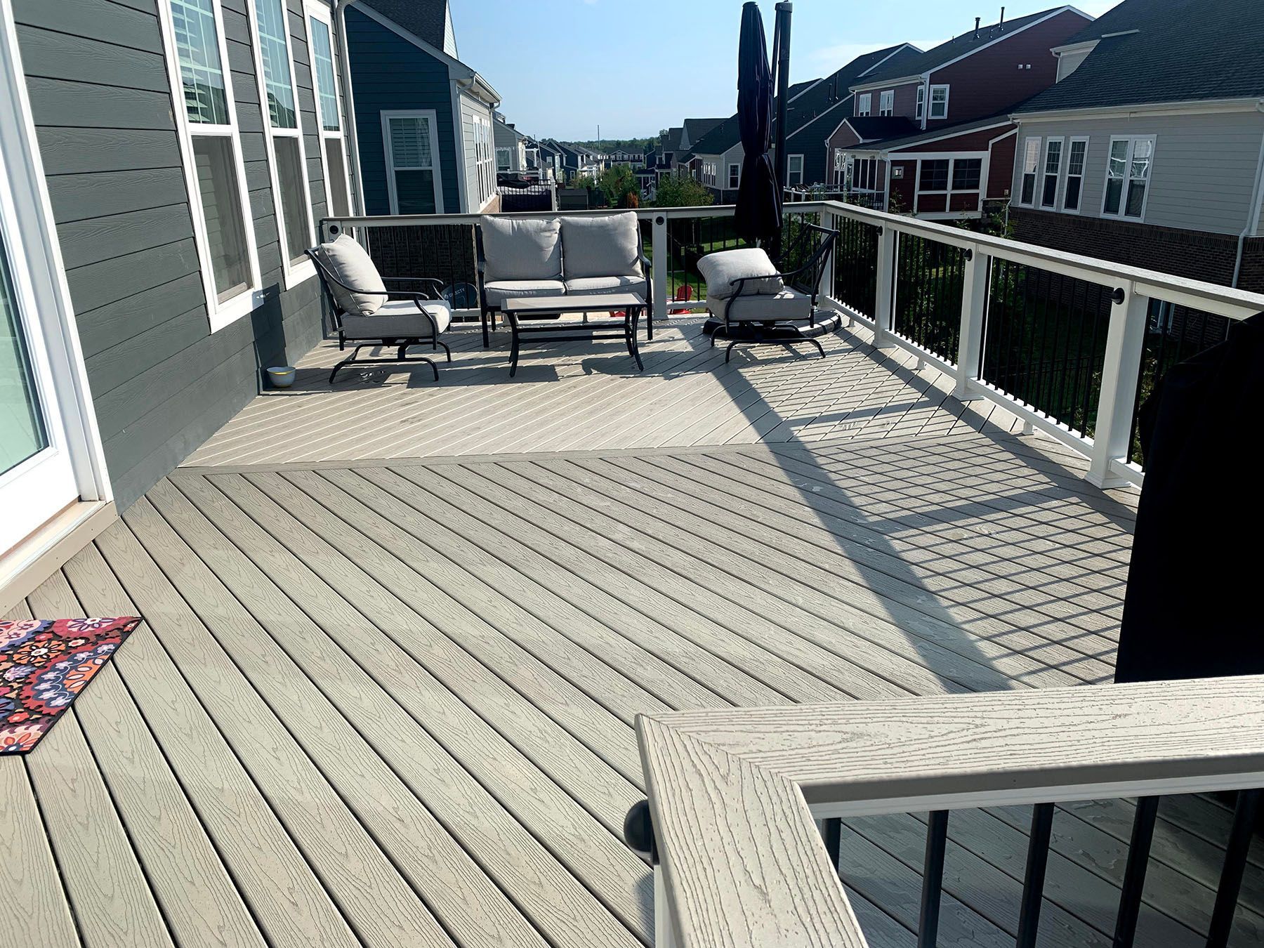 There is a large deck with a couch and chairs on it.