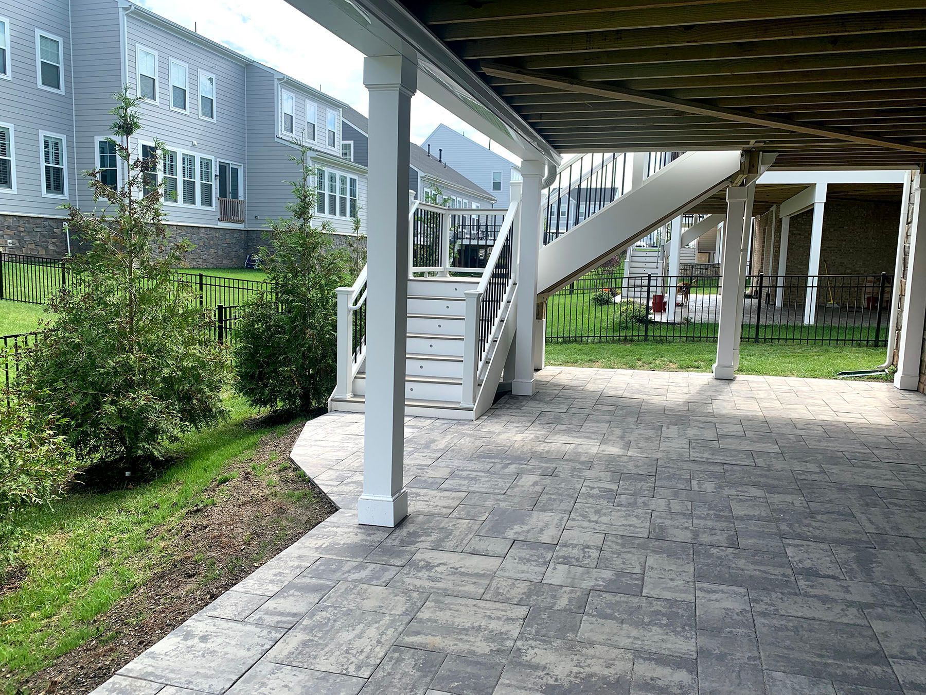 A covered patio with stairs leading up to a house