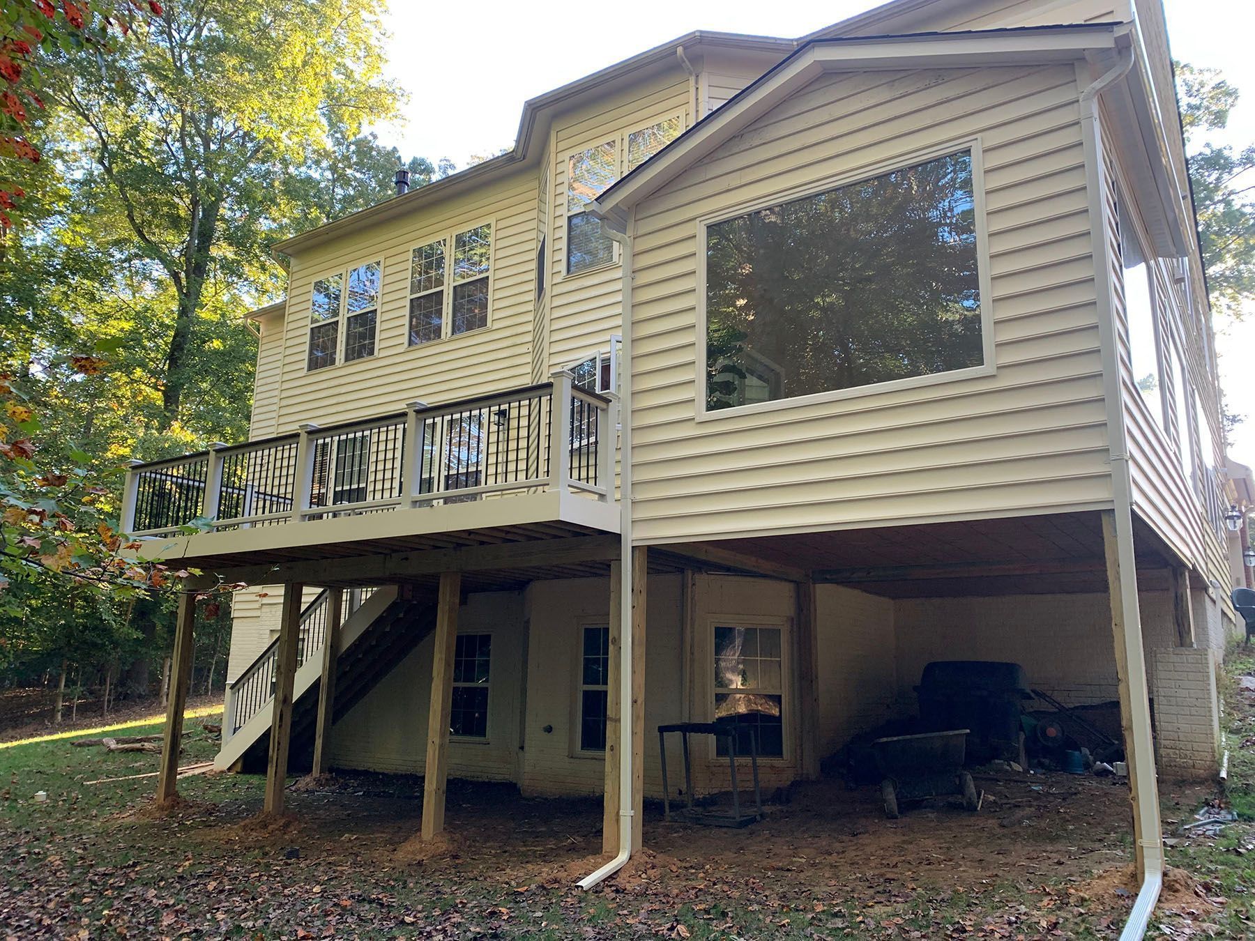 The back of a house with a large deck and stairs.